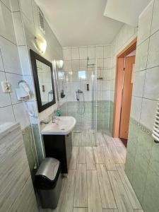 uma casa de banho com um chuveiro, um lavatório e um chuveiro em Pensjonat Albatros Pogorzelica em Pogorzelica