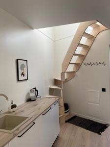 a kitchen with a spiral staircase in a house at Treehouse Virš Bedugnės in Jurbarkas