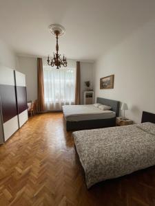 a hotel room with two beds and a chandelier at Family Home in Budapest