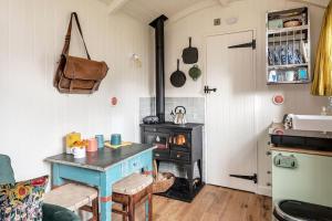 a kitchen with a stove and a table in a room at The Rumple Hut in Wingfield