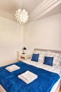 a bedroom with a bed with blue sheets and a chandelier at Blue Amber in Rumia