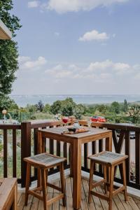 een houten terras met een tafel en twee krukken bij Hôtel Le Romantica in Pennedepie