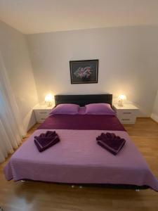 a bedroom with a purple bed with two purple pillows at Apartments Lovely Croatia in Bol