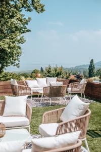 un groupe de chaises et de tables en rotin sur une pelouse dans l'établissement Hôtel Le Romantica, à Pennedepie