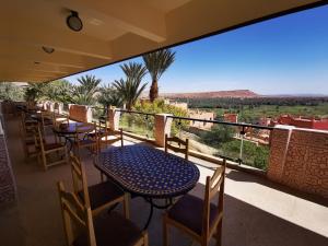 d'un balcon avec des tables et des chaises et une vue sur le désert. dans l'établissement Hotel Saghro, à Tinghir