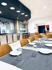 a restaurant with a long table with chairs and plates on it at Hôtel de Lyon in Valence