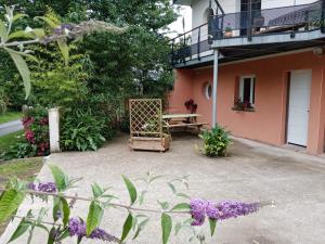 un patio di una casa con panchina e fiori di Hentig ar Feunteun a Plouaret