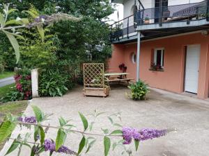 a patio of a house with a bench and flowers at Hentig ar Feunteun in Plouaret