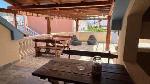 a balcony with a wooden table and a table and benches at Apartment 39 in Vir