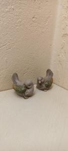 two figurines of birds sitting next to a wall at Barackvirág Apartmanház in Vonyarcvashegy