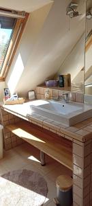 a bathroom with a sink in a attic at Barackvirág Apartmanház in Vonyarcvashegy