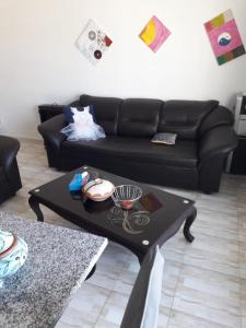 a living room with a black couch and a coffee table at Monastir cap Marina in Monastir