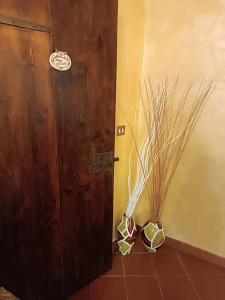 deux vases assis sur le sol à côté d'une porte dans l'établissement Casa storica in borgo medioevale, à Segni