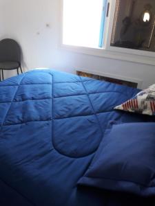 a blue comforter on a bed in a bedroom at Monastir cap Marina in Monastir