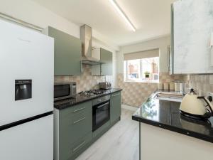 a kitchen with green cabinets and a stove top oven at Pass the Keys 2BDR Peaceful Ground Floor Apartment Free Parking in Wokingham