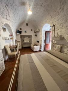 a living room with a table and a stone wall at Casa Il Rosone in Carovigno