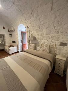 a bedroom with a bed and a stone wall at Casa Il Rosone in Carovigno