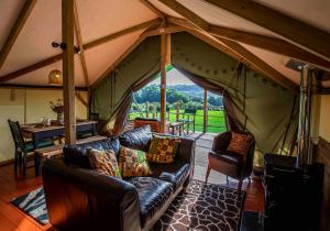 a living room with a couch and a tent at Hakuna Matata Safari Lodge - Sublime, off-grid digital detox with hot tub in Shelsley Walsh