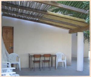 a table and chairs sitting under a wooden roof at Villaliana in Torre Dei Corsari