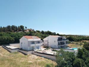 eine Luftansicht von zwei weißen Häusern auf einem Hügel in der Unterkunft Vila Cissa in Novalja