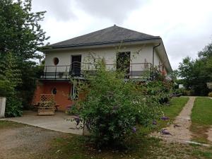 a white house with a balcony and a yard at Hentig ar Feunteun in Plouaret
