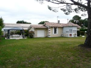 a house with a lawn in front of it at MAISON Classée 3* in Gujan-Mestras