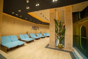 una sala de espera con una fila de sillas azules en Aria Club Wellness&Spa Zlatibor en Zlatibor