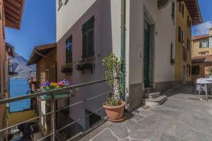 a balcony of a building with potted plants on it at Casa Ferrari in Varenna