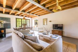 Una sala de estar con un sofá y un televisor. en La Bergerie, en Argelès-sur-Mer