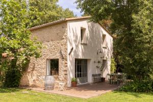 Elle offre une vue sur l'extérieur d'une maison en pierre dotée d'une terrasse. dans l'établissement La Bergerie, à Argelès-sur-Mer
