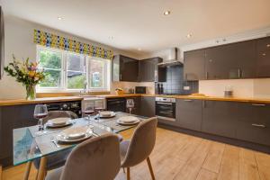 une cuisine avec une table à manger et des chaises ainsi qu'un astérisque dans l'établissement Cobblers Cottage, Wells Next The Sea, à Wells-next-the-Sea