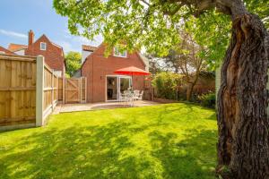 une cour avec une clôture et une maison dans l'établissement Cobblers Cottage, Wells Next The Sea, à Wells-next-the-Sea