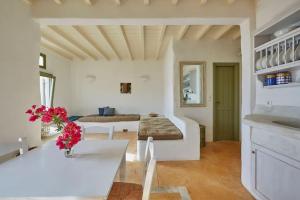 ein Wohnzimmer mit einem Bett und einem Tisch in der Unterkunft Ochre Dream, Beach front & Sunset villa Naousa in Naoussa