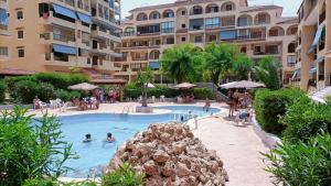 a swimming pool in a resort with people in it at Grace resident stúdió apartman in La Mata