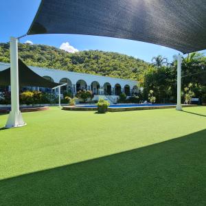 a large lawn with a building in the background at Island Serenity on Magnetic Island in Nelly Bay