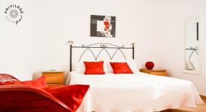 a bedroom with a white bed with red pillows at Villa Privilege Sun in Corralejo