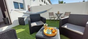 - une terrasse avec 2 chaises et une table avec un bol de fruits dans l'établissement Casa Papillon, à Sagres