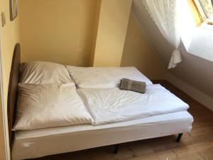 Una cama con sábanas blancas y una toalla. en Krissun, en Pobierowo