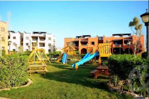 a playground with a slide in a yard with buildings at Luxury Chalet With Roof at Nice 4 North coast kilo 75 نيس ٤ in Dawwār Abū Duray‘ah ‘Abd al Karīm