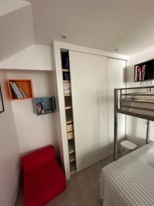 a bedroom with a bunk bed and a red chair at Appartement des Lices in Saint-Tropez