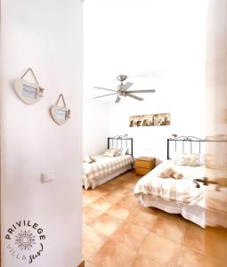 a bedroom with two beds and a ceiling fan at Villa Privilege Sun in Corralejo