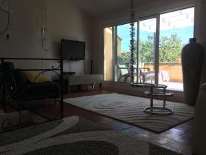 a living room with a couch and a table and a window at Duplex Cosy Vue Colline in Cavaillon