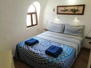 a bedroom with a bed with two blue pillows on it at Oasi Sul Mare - Bungalow a 120m dalla spiaggia in Sciacca