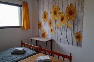 アルビにあるVilla Ginkgo-955 avec SPA privatifの花の絵が飾られたベッドルーム