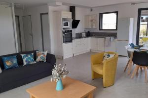 ein Wohnzimmer mit einem Sofa und einem Tisch sowie eine Küche in der Unterkunft Villa Ginkgo-955 avec SPA privatif in Albi