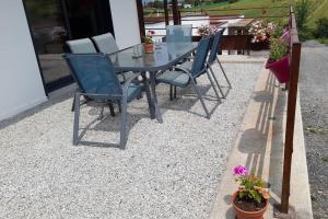 un tavolo in vetro e sedie su un patio di ghiaia di Villa Ginkgo-955 avec SPA privatif ad Albi
