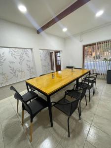 uma grande mesa de madeira e cadeiras num quarto em SOUL B&B em El Calafate