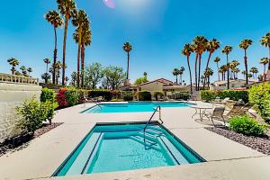 a swimming pool with a table and chairs and palm trees at Mesquite Country Club Condo O64 - Permit # 4552 - 7 night minimum stay in Palm Springs