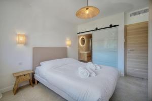 a bedroom with a white bed with towels on it at Cannes Luxury Rental - Stunning renovated 2 bedroom apartment in Cannes