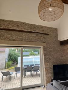 a living room with a patio with a table and chairs at La Maison de Zoé in Saint-Denis-sur-Loire